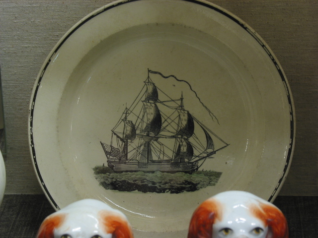 Bord met de afbeelding van een fregat op een groene zee.