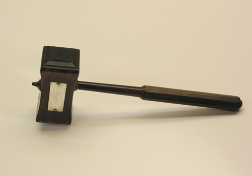 Een houten voorzittershamer met op het plaatje het opschrift 'Scheepsbouwvereniging Hoogezand 1900-1960'