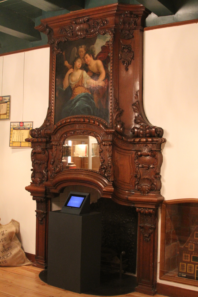 Houten schouw met ingebouwde spiegel en schoorsteenstuk voorstellend Bacchus en Ariadne door Jan Abel Wassenbergh uit 1741 (gesigneerd). Snijwerk met bladermotieven) door Casper Struiwig (toegeschreven) (1698-1747)