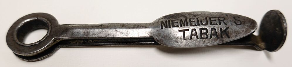 Pijpenpeuter en stopper van ijzer met opschrift 'Niemeyer's Tabak', 20e eeuw