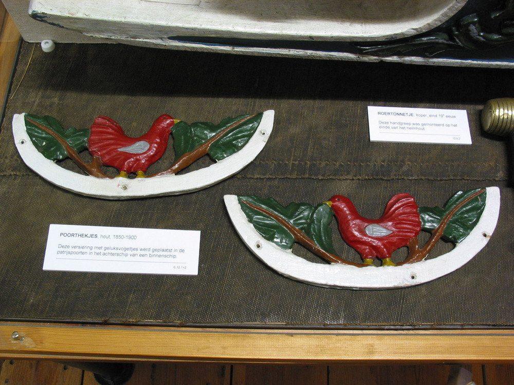 Poorthekjes in de vorm van een vogeltje, versiering in de patrijspoorten in het achterschip van een tjalk.