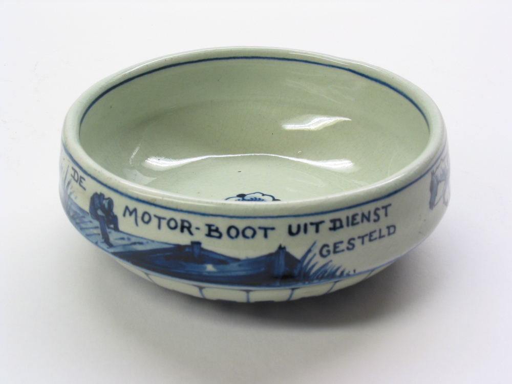 Schaaltje van Delfts aardewerk met opschrift "De motorboot uit dienst gesteld. De trekschuit weer in eer hersteld 1917". Vervaardigd naar aanleiding van de brandstofschaarste in 1917