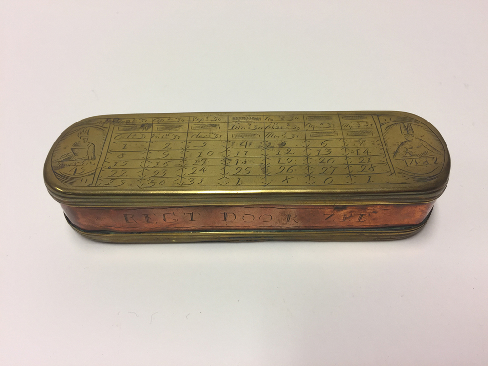 Holm tabaksdoos, deksel en onderzijde van geelkoper, daartussen roodkoper. Tabaksdoos van Pieter Holm, Amsterdam, 18e eeuw. Op de voorzijde een eeuwigdurende kalender en afbeeldingen van Julius Caesar en Paus Gregorius en op de achterzijde een zeemeter en een afbeelding van Amerigo Vespucci.