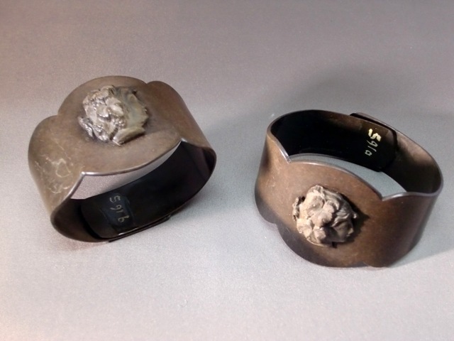 Vier rouwarmbanden met reliëf