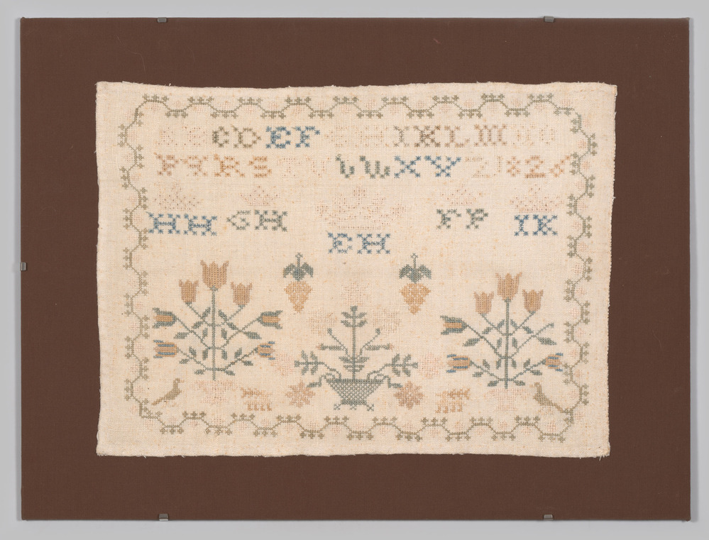 Merklap vastgenaaid in de lijst