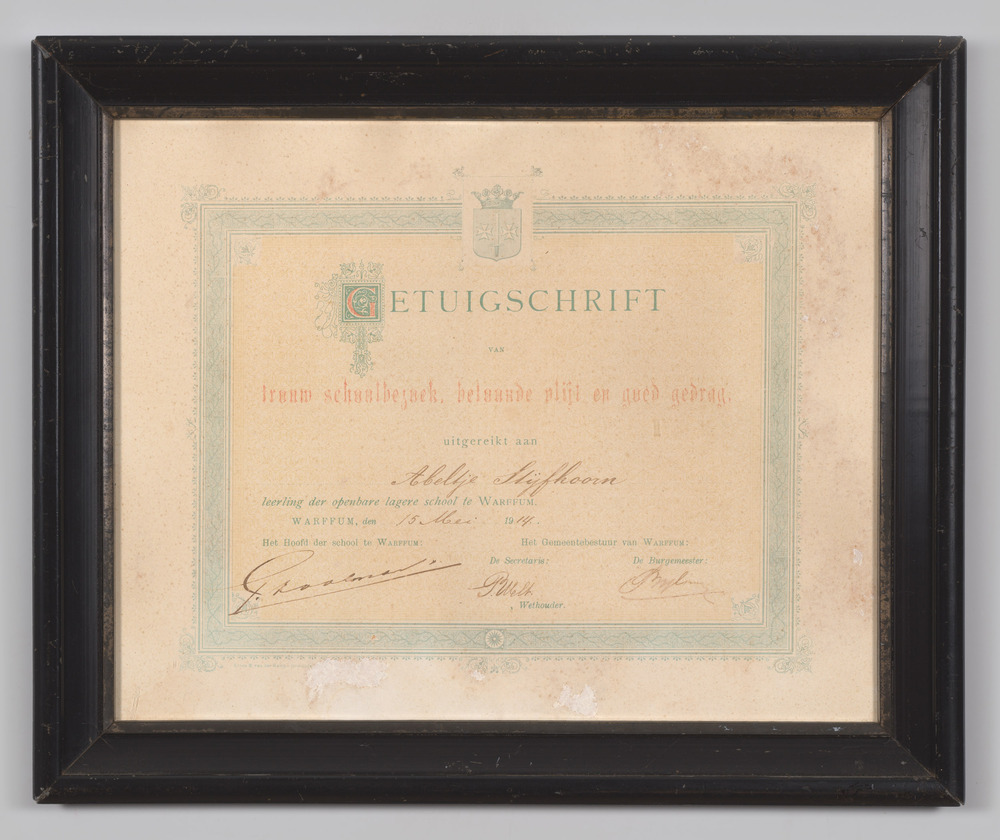 Getuigschrift, ingelijst, achter glas, van de lagere school