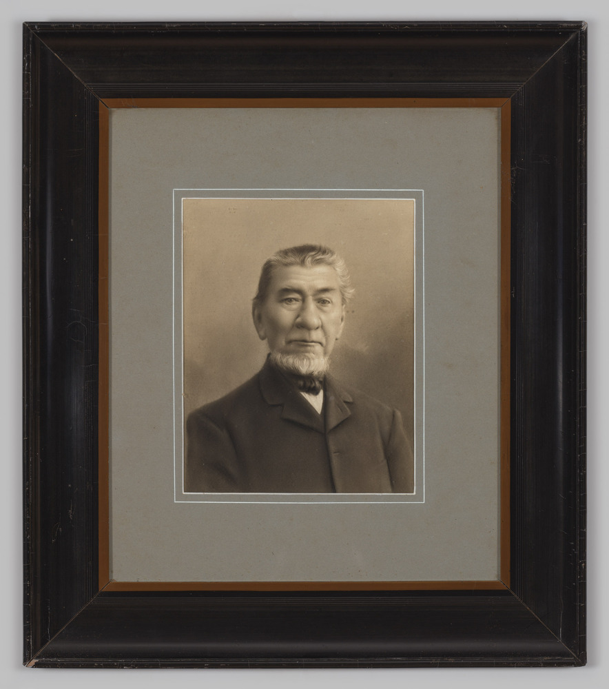 Portretfoto's, achter glas, voorstellende een man,