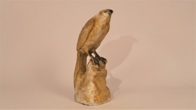 Beeld voorstellende (roof)vogel zittend op rotsblok