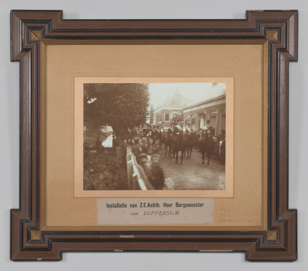 Foto, ingelijst, achter glas, voorstellende de optocht bij de aanvaarding van het ambt door de burgemeester van Loppersum