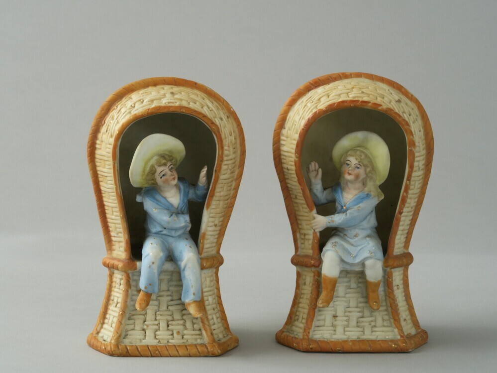 Twee aardewerken strandstoelen met een jongen en meisje