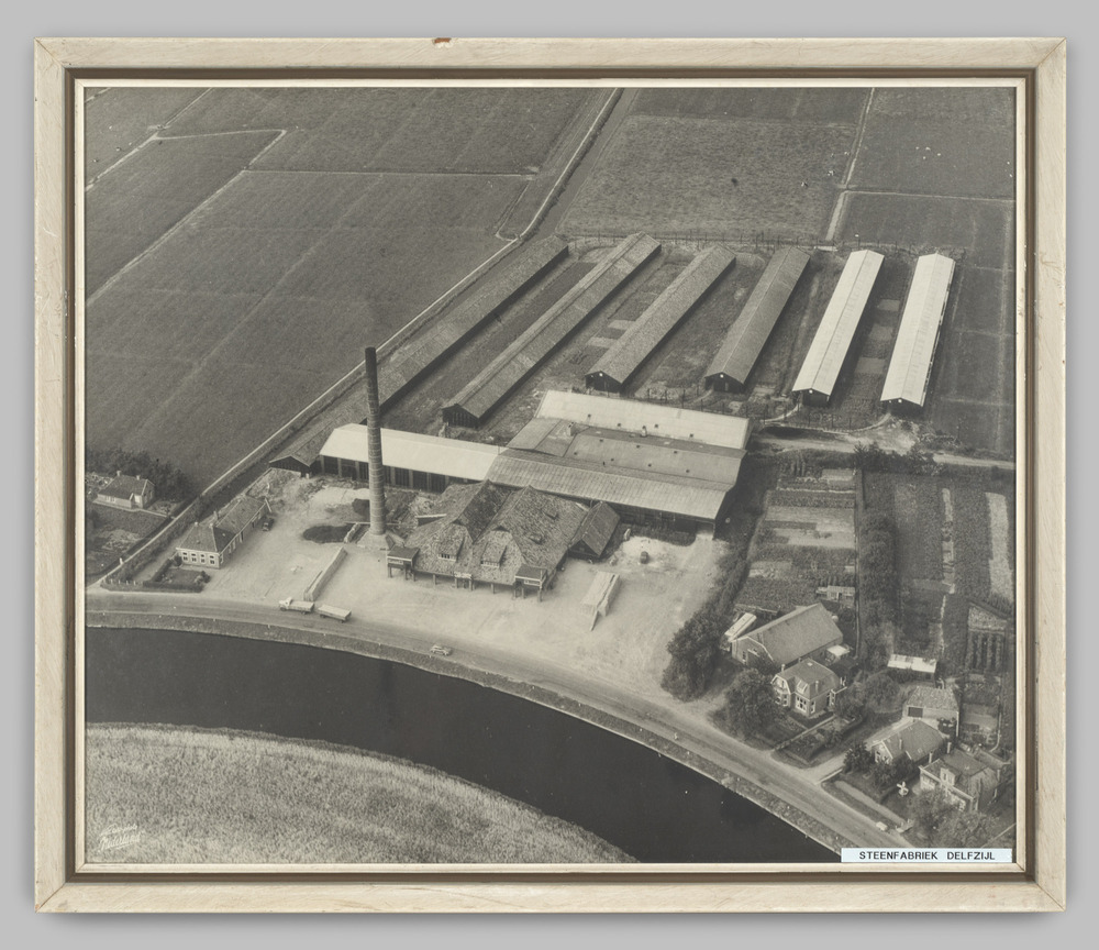 Luchtfoto van steenfabriek Delfzijl, ingelijst, achter glas
