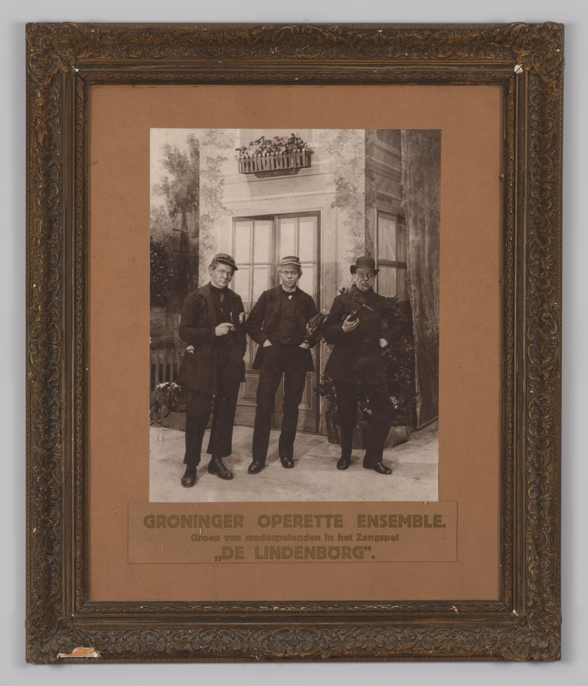 foto van drie mannen voor een toneeldecor