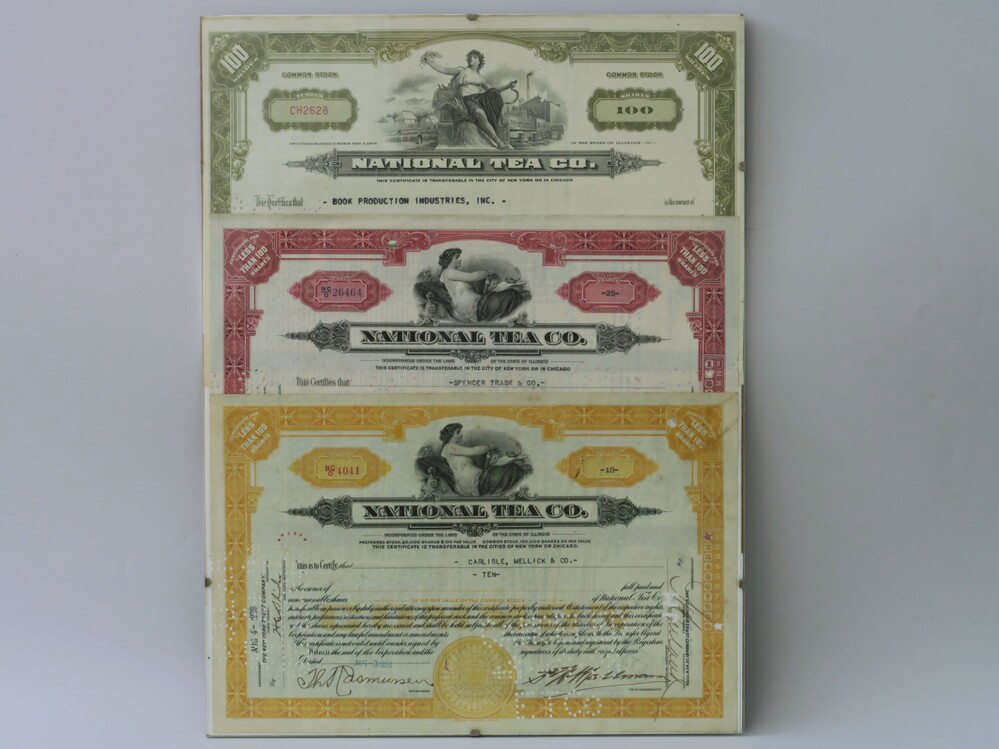 Certificaten van aandeel/ aandeelbewijzen, drie stuks, van The National tea company, een Amerikaanse supermarktketen van de 20e eeuw, met daarop tekst en tekening van een vrouw. Ingelijst
