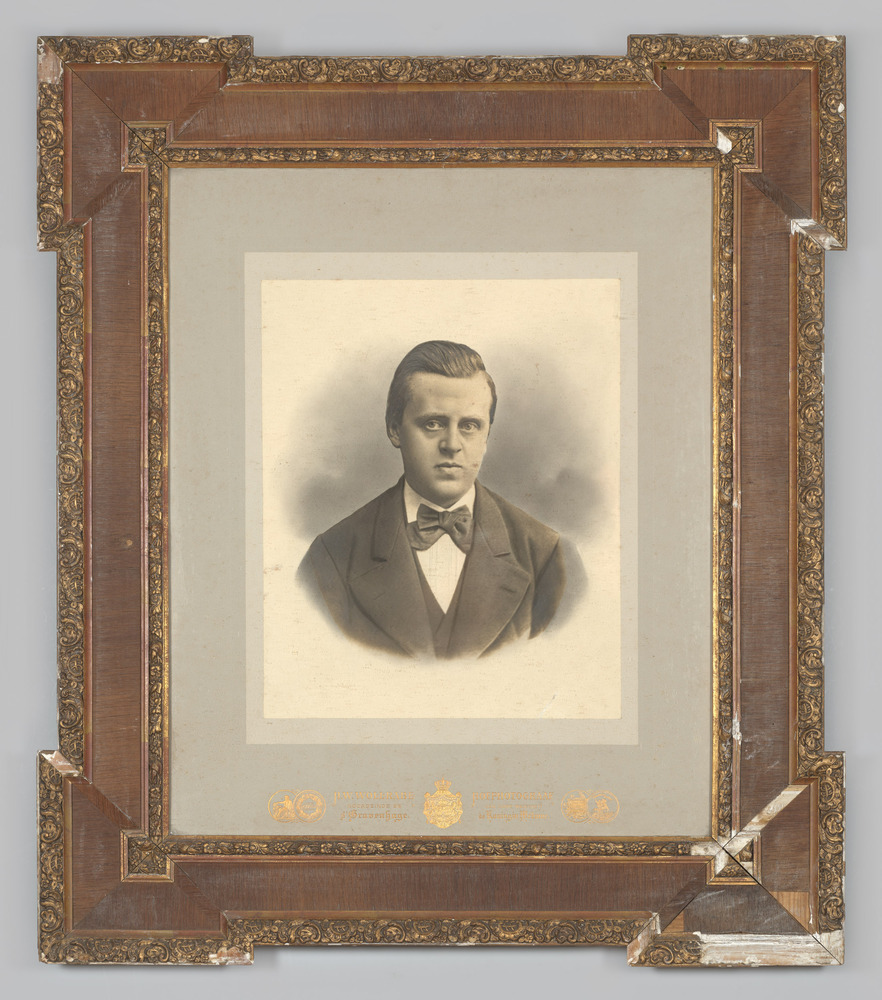 Portretfoto van een man, ingelijst, achter glas