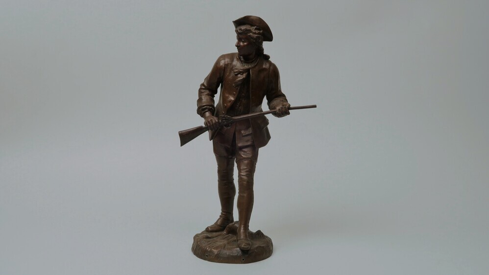 Beeld van een staande man met wapen in zijn handen