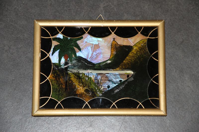 glasschildering van een gezicht op de baai te Rio de janeiro, met aan de overkant de suikerbroodberg en de rots met het kruis, in goudkleurige hout met gipsen lijst, alles in het zwart, groen en goud, opgevuld met vlindervleugels. In 1991 aangekocht op de rommelmarkt van de Herv. kerk van west. Afkomstig van Heere Bloem die het in 1950 in Santos (Brazilie) kocht. Heere was scheepswerktuigkundige aan boord van het SS.Eemland (Kon. Holl. Lloyd). De berg op het schilderijtje is de Pao da Sugare (suikerbroodberg). Bovenop de berg staat het beroemde Corpo Vado, het 30 m. hoge Christusbeeld. De berg geeft een uitzicht over de baai van Rio de Janeiro.