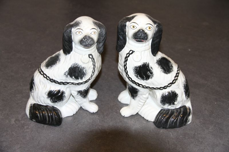 setje van 2 steengoed Staffordshire honden in de vorm van een King Charles Spaniel, zwarte vlekken alom, witte voorpoten met zwarte nageltjes, 1 voorpoot los van lichaam. zwarte ketting over borst naar rug en witte nekhanger, linker exemplaar iets kleiner dan rechter exemplaar, 13,1 x 17,5 x 22,7 cm & 12 x 18,7 x 24,5 cm, Staffordshire, ongeveer 1880 - 1900