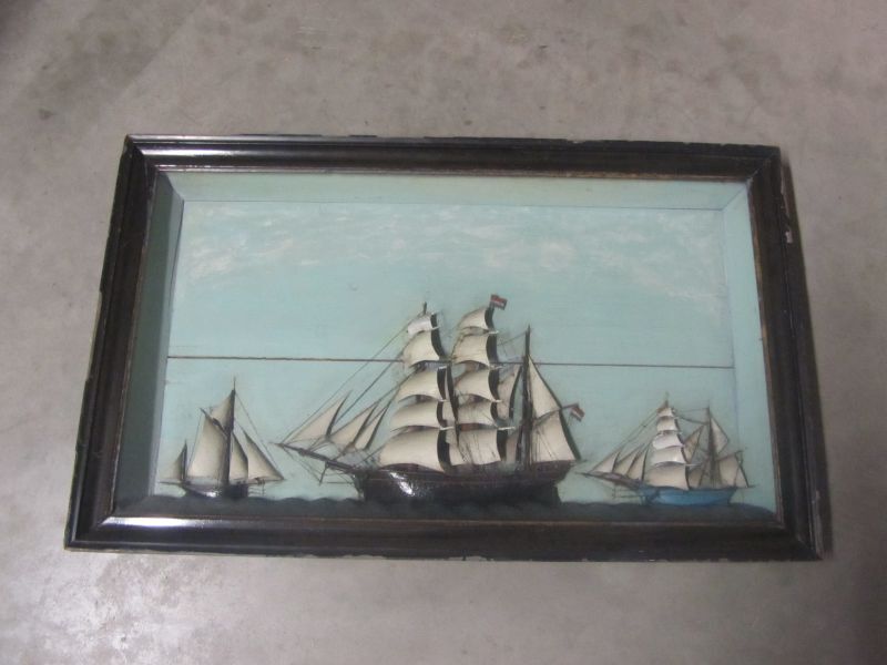 kastmodel van een zeilschip, links en rechts geflankeerd door een kleinere schip