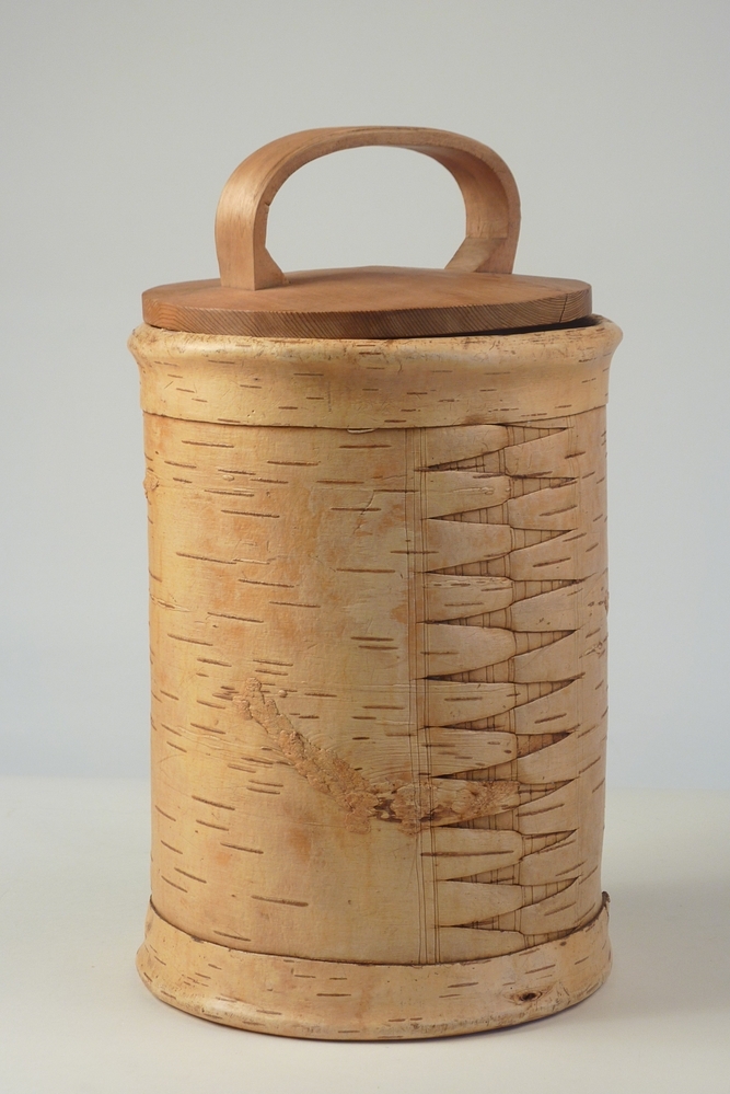 De Toejas is een cylindervormige doos gemaakt van berkenbast. De wand bestaat uit twee lagen berkenbast , die met de zilverwitte buitenkant van de schors tegen elkaar liggen. De deksel en bodem zijn gemaakt van een rond gesneden stukje grenehout. De doos is versierd met gestempelde en uitgesneden geometrische figuren.Deze dozen werden en worden nog steed vervaardigd in dorpen in de omgeving van Veliky Ustyug, een plaats in het Noordoosten van Europees Rusland. Zij worden in die streek "Tuyes" genoemd en door een groot deel van Noord - Oost Rusland verhandeld. In Rusland worden dit soort dozen nog steed gebruikt voor het vervoer van zuivelprodukten, terwijl ze in het Noorden van ons land als tabakspot dienst deden.