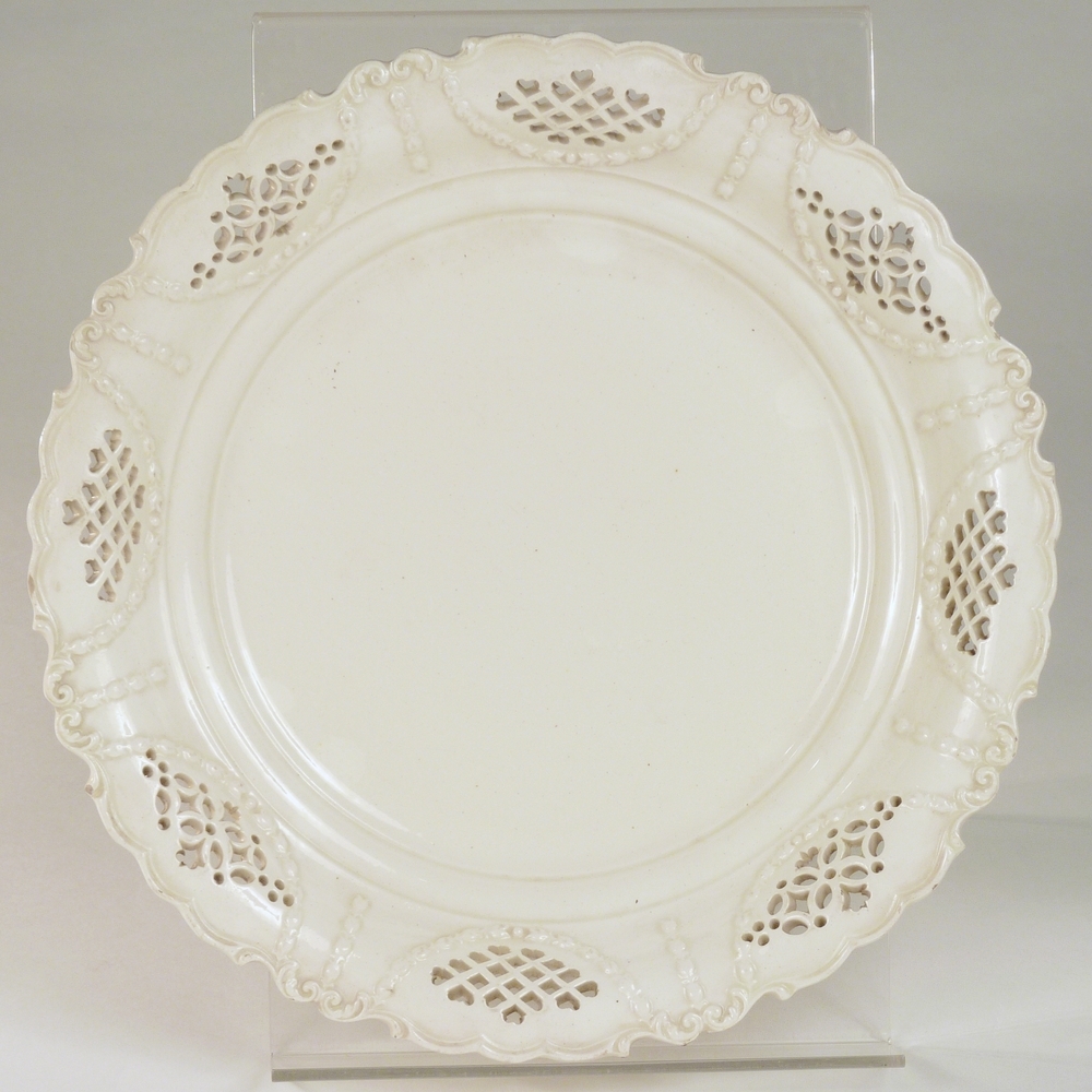 creamware bord met ajourwerk en bloemenrank en geschulpte rand