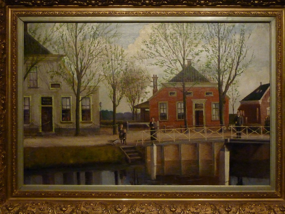 Olieverfschilderij, schilder onbekend. Titel : Dorpsgezicht in tripscompagnie. Afgestaan aan het Veenkoloniaal Museum. De voorstelling betreft het oude schoolgebouw , waar de heer E.F.W.Brinkman onderwijzer - publicist te Muntendam, jarenlang les heeft gegeven , alsmede het cafe - winkeltje van de familie Talens.