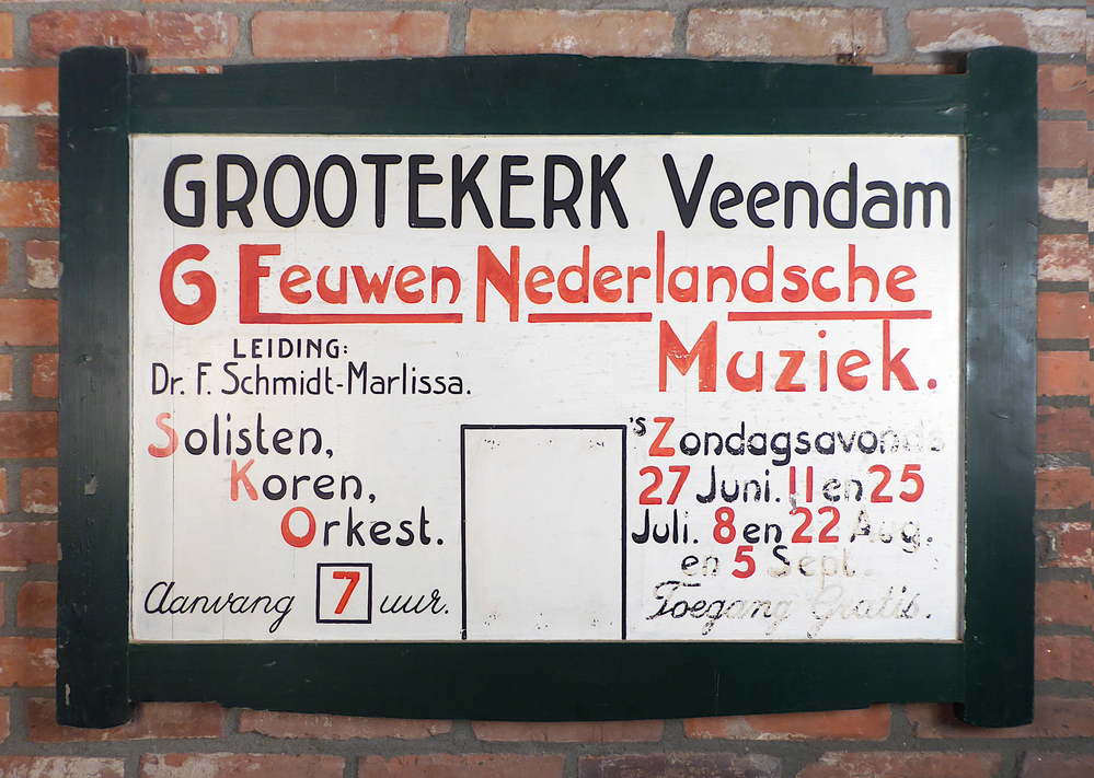 houten uithangbord, groene rand met witte binnenkant , zwart en rode belettering: Grootekerk Veendam, 6 eeuwen Nederlandsche Muziek, leiding Dr. F. Schmidt-Marlissa 1937