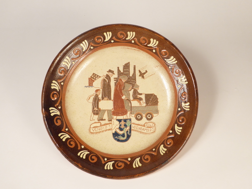 Een grote ronde sierbord van roodbakkende aardewerk met op de binnenkant een afbeelding van een voor het oorlogsgeweld vluchtend gezin, bestaand uit een man en vrouw met kinderwagen en kinderen, op de achtergrond een vliegtuig met een ingestorte brug en een ruïne, duidende op de vele bombardementen, midden onder het gemeentewapen van Veendam geflankeerd door een banier met de tekst Venlo 17 -1 en 1945 Veendam 27-5. Rondom een sierrand met geometrische motieven. Geschonken aan de familie Doornbosch door de fam. Roodheem uit Venlo, evacue's.
In de wijk Plan Noord die na de oorlog tot stand kwam, werd een gedenkbank geplaatst met de tekst Venlo bedankt Veendam, geplaats op dinsdag 31 mei 1955 tijdens het 300 jarig bestaan van Veendam.