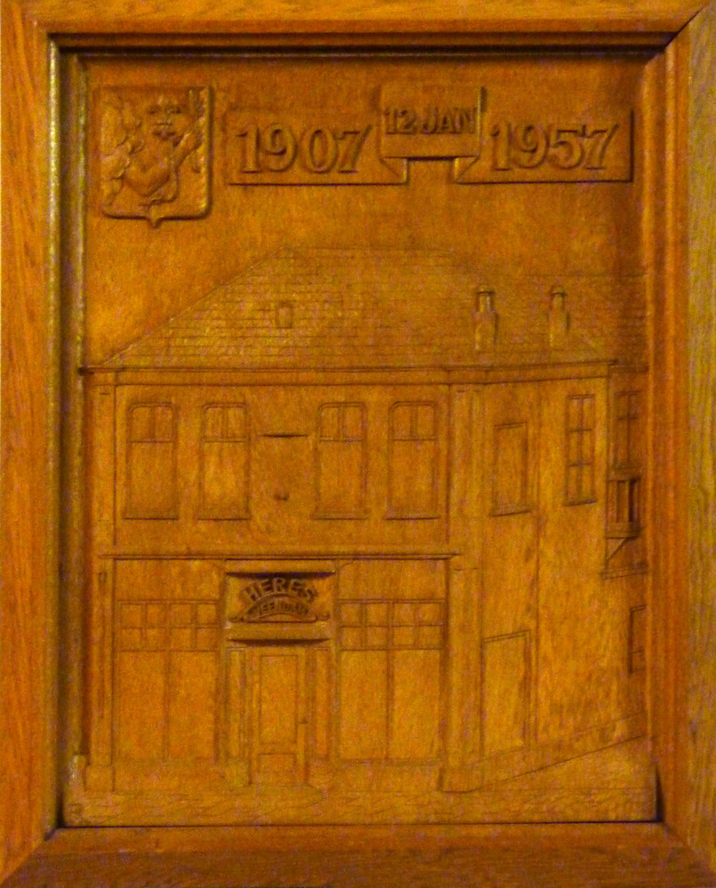 houten plak met hierin uitgebeiteld het gebouw van meubelfabriek Heres, met boven inscriptie 1907 12 jan 1957, en in boog boven deur Heres Veendam.