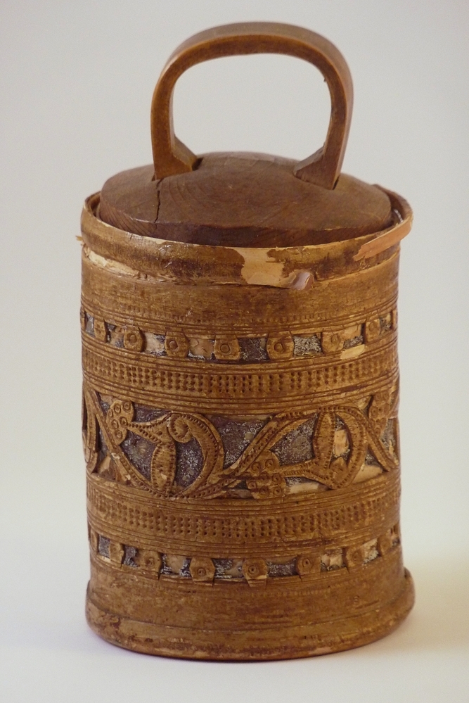 De Toejas is een cylindervormige doos gemaakt van berkenbast. De wand bestaat uit twee lagen berkenbast , die met de zilverwitte buitenkant van de schors tegen elkaar liggen. De deksel en bodem zijn gemaakt van een rond gesneden stukje grenehout. De doos is versierd met gestempelde en uitgesneden geometrische figuren.Deze dozen werden en worden nog steed vervaardigd in dorpen in de omgeving van Veliky Ustyug, een plaats in het Noordoosten van Europees Rusland. Zij worden in die streek "Tuyes" genoemd en door een groot deel van Noord - Oost Rusland verhandeld. In Rusland worden dit soort dozen nog steed gebruikt voor het vervoer van zuivelprodukten, terwijl ze in het Noorden van ons land als tabakspot dienst deden.