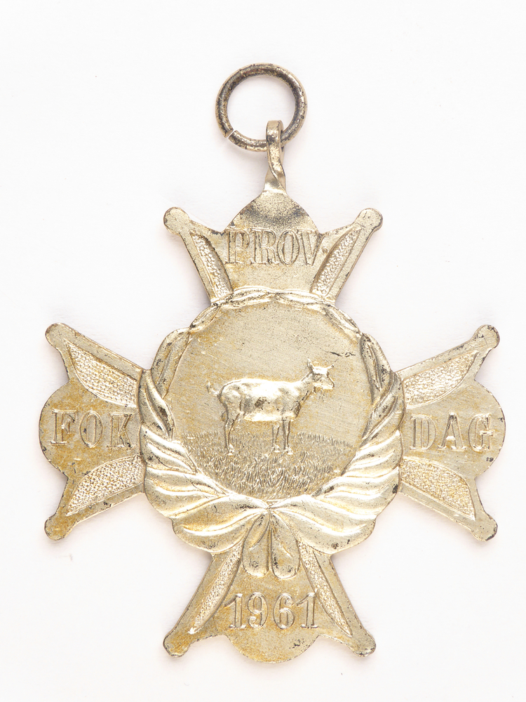 zilverkleurige stervormige medaille met op voorkant op de armen Prov Fok Dag 1961, in het midden afbeelding van een geit met daaronder een krans, op achterkant inscriptie 2 B S 80 H Dijkstra