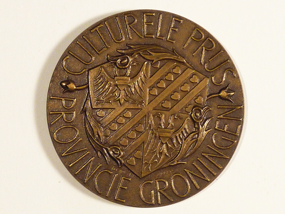 bronzen prijspenning met rondschrift culturele prijs Provincie groningen in cirkelvorm 4 culturele afbeeldingen toneel muziek schilderen literatuur