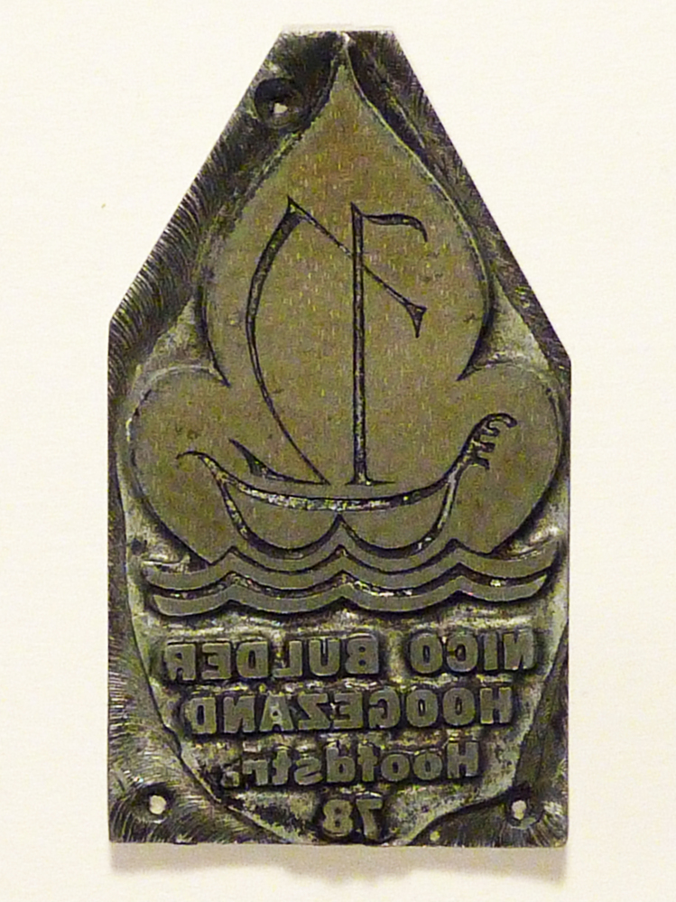 metalen cliche met in matrijs een zeilschip op het water en tekst  Nico Bulder Hoogezand Hoofdstraat 78