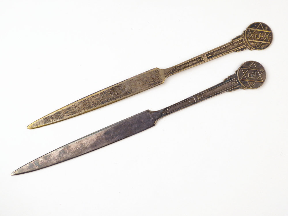 langwerpige spitse verzilverde messingen briefopener met op uiteinde decoratie S in ster, aan achterzijde gegraveerd W.A.Scholten's aardappelmeelfabrieken Groningen (Holland), diverse stempelingen achterkant p in cirkel, l in rchthoek, dubbel e in rechthoek t in ruit