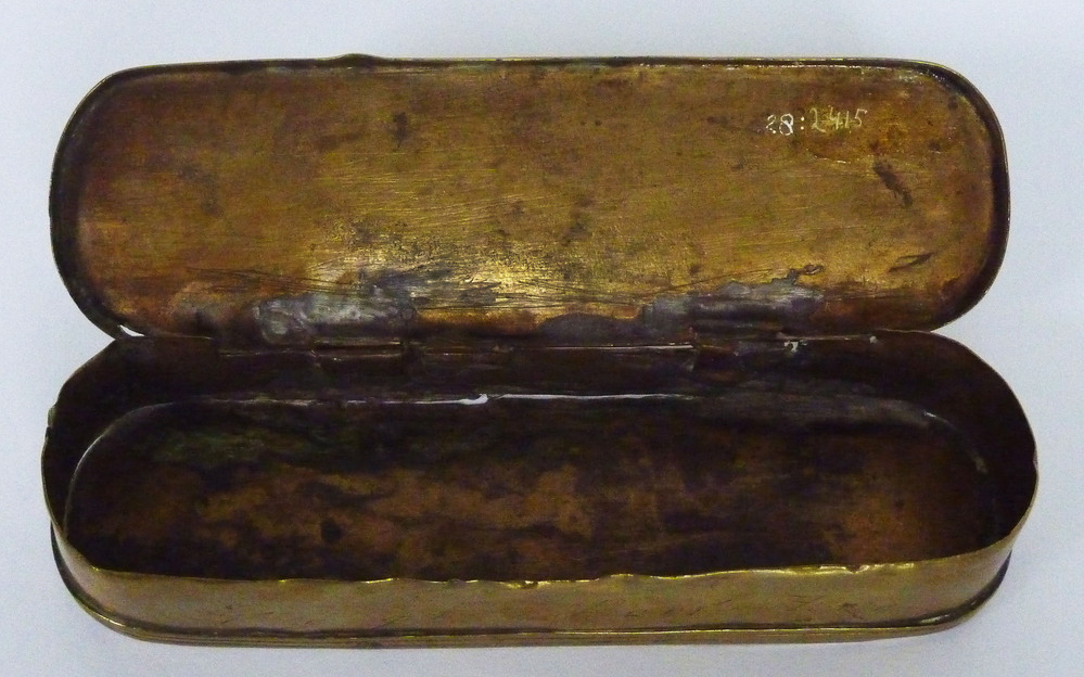 Een voorwerp uit de categorie scheepvaart. Een ovale tabaksdoos van 15,5 cm lang, 5 cm breed en 3 cm hoog, met scharnierend deksel van koper en messing. Dit doosje vertoond overal sterke slijtsporen en zal dus veel gebruikt zijn. Ook is het al eens gesoldeerd aan de bovenkant en er missen delen van het scharnier. Dit tabaksdoosje is voorzien van een eeuwigdurende kalender op het deksel en een snelheidstabel voor schepen op de bodem. Het deksel is verder versierd met eenvoudige afbeeldingen, voorstellende aan de linker bovenkant Julius Caesar en aan de rechterbovenkant paus Gregorius XIII, met daaronder respectievelijk “voor Krist 45” en “1582”. Zij stellen de Juliaanse kalender en de Gregoriaanse kalender voor. De onderkant bevat een eenvoudige afbeelding van een persoon met een wereldbol en het jaar 1497, die door deskundigen voorlopig is geïdentificeerd als Amerigo Vespucci. Meestal staat er onderaan ook een korte Nederlandse tekst: “Den eeuwig durenden Almanak”. Pieter Holm bestelde de dozen bij een graveur en dat wordt bevestigd door de vlotte graveertrant van de cijfers op deze dozen. Holmdozen zijn in artistiek opzicht wel het minst aantrekkelijk. De gravering van deze Holmdozen is sterk industriematig: het lijnenwerk lijkt langs een liniaal te zijn getrokken en de vakjes zijn vervolgens op vluchtige wijze met de burijn ingevuld. Dat diende overigens wel zorgvuldig te gebeuren omdat deze tabellen een rekenfunctie hadden die bij fouten de gebruikswaarde van de doos ernstig zou aantasten. Duidelijk is dat dit handgraveerwerk snel is verricht met een minimaal draaien van de doos. Zo zien we dat de cijfers 6, 9 en 0 opgebouwd zijn uit twee vlotte graveersteken, de rompen zijn door die werkwijze licht puntig geworden. De meeste Holmdozen dragen een datering tussen 1729 en 1775. Daarmee omspannen zij ook de bloeitijd van de Hollandse gegraveerde tabaksdoos. Bij dit exemplaar is de tekst almanak weggesleten. De laatste vier cijfers op de bovenkant rechtsonder, in dit geval 1806, vormen samen de vervaardigingdatum van deze tabaksdoos. Op de verticale voorzijde staat: “Regt door zee”. Op sommige exemplaren tevens de rijmtekst 'Geen konst maar rijkdom kan men verlise, daarom wilt konst voor rijkdom kise'. De verzamelaar van tabaksdozen of andere nautische instrumenten herkend het al: Het is een tabaksdoos, bedacht door Pieter Holm (1685/86 – 1776), een gepensioneerd Zweedse zeeman die in 1720 te Amsterdam kwam wonen en vanaf ongeveer 1737 had hij hier een school met de naam: “Regt door Zee”, waar hij les gat in de zeemanskunst. De naam “Regt door Zee” refereert hier aan een zeereis uit 1720 die Pieter Holm zou hebben gemaakt op het schip “Regt door Zee”, maar hier is nooit enkel bewijs voor gevonden en het lijkt erop dat hij dit verhaal uit de duim heeft gezogen. Hij kwam op de school op het idee om een zeemeter te laten graveren in koperen tabaksdozen, bij wijze van almanak. Eeuwenlang was het gissen hoe snel het schip voer en moesten de officieren de snelheid van hun schip schatten. Nu hadden ze daarvoor een handig hulpmiddel, een tabaksdoos! Eerst gaan twee mannen aan boord op 12,5 meter afstand van elkaar staan. De voorste gooit een voorwerp naar voren en overboord. Hij roept als het hem passeert. De tweede man telt het aantal seconden tot het voorwerp hem passeert. Op een tabel kon vervolgens de snelheid worden afgelezen. Hoewel er nooit merkjes werden gevonden wie de vervaardiger van deze tabaksdozen was, lijkt het erop dat ze gemaakt werden te Iserlohn (Duitsland), waar ze naar Amsterdam werden verscheept. Of de kalender en andere informatie al op de dozen was gegraveerd of later werd toegevoegd in Amsterdam is niet bekend. De productie en verkoop van deze tabaksdozen begon tijdens het leven van Pieter Holm en ging tot ver na zijn dood door, tot ongeveer 1817. Pieter Holm verkocht als neven inkomsten aan zijn leerlingen op school allerlei kaarten en instrumenten, waaronder ook deze zeemeters. Hij vroeg hier ƒ 5,- en 10 stuivers voor.  Ze vonden later gretig aftrek binnen heel Europa. Vele exemplaren daarvan vindt men nu in verschillende musea, bv te Leeuwarden, Middelburg, Groningen, Lübeck, Lund, Bordeaux, Rotterdam, Reykjavik, Oslo en Kopenhagen. Het Veenkoloniaal Museum kreeg deze tabaksdoos in 1985 in bruikleen van dhr. A. Bakker. Op de voorkant staat een foutje. Er staat 1482, en het moet zijn 1582! Daar is wel een verklaring voor. Er zijn vele verschillende versies gevonden van deze tabaksdozen, en waarschijnlijk werden ze onderling gekopieerd onder zeelieden, en dan is een foutje snel gemaakt. In 2022 verkreeg het Veenkoloniaal Museum weer zo’n tabaksdoos. Ditmaal vertelde de schenker erbij dat deze vermoedelijk gemaakt was door een van zijn leerlingen, Arend (S)Zwieter, die na zijn Holm’s dood in 1776 verder ging met de productie van de dozen. De laatste vier cijfers op de tabel vormen de datering van de doos.