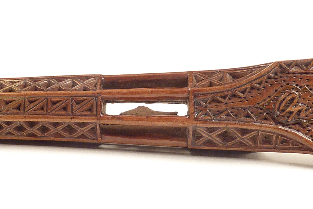 Gestoken houten breischede, 20 x 3,4 cm , langwerpig, met brede spatelvormige blad en dunner wordende  handgreep in de vorm van een kooitje, rijkelijk versierd met geometrische figuren, met op het blad de inscriptie: A.Roelfsema geflankeerd door de cijfers 18 en 97 en op de keerzijde: op uwe verjaring en twee handen. Het kooitje is van binnen uitgehold door enkele gleuven en bevat een klein houten schoentje, het zieltje, dat ontstaan is, doordat door die gleuven in het binnenste een stukje hout werd uitgespaard, dat eindelijk als balletje geheel vrij kwam te liggen én nu bij het schudden van de breischede rammelt. Afkomstig van Annechien Roelfsema toen ze in 1897 54 jaar oud werd. Annechien Roelfsema, werkvrouw, geboren 28-12-1845 te Veendam, overleden 26-01-1925 te Wildervank, dochter van Hindrik Riemts Roelfsema en Grietje Harms Jonker, getrouwd op 01-08-1874 te Wildervank met Hidde Poppen, zoon van Harm Hilbrands Poppen en Henderkien Hiddes Keizer, geboren 09-03-1850 te Wildervank, van 1874 - 1876 schoenmaker te Wildervank, van 1876 - 1889 steenbakker te Wildervank, van 1900 - 1901 brandmeester op een steenfabriek.