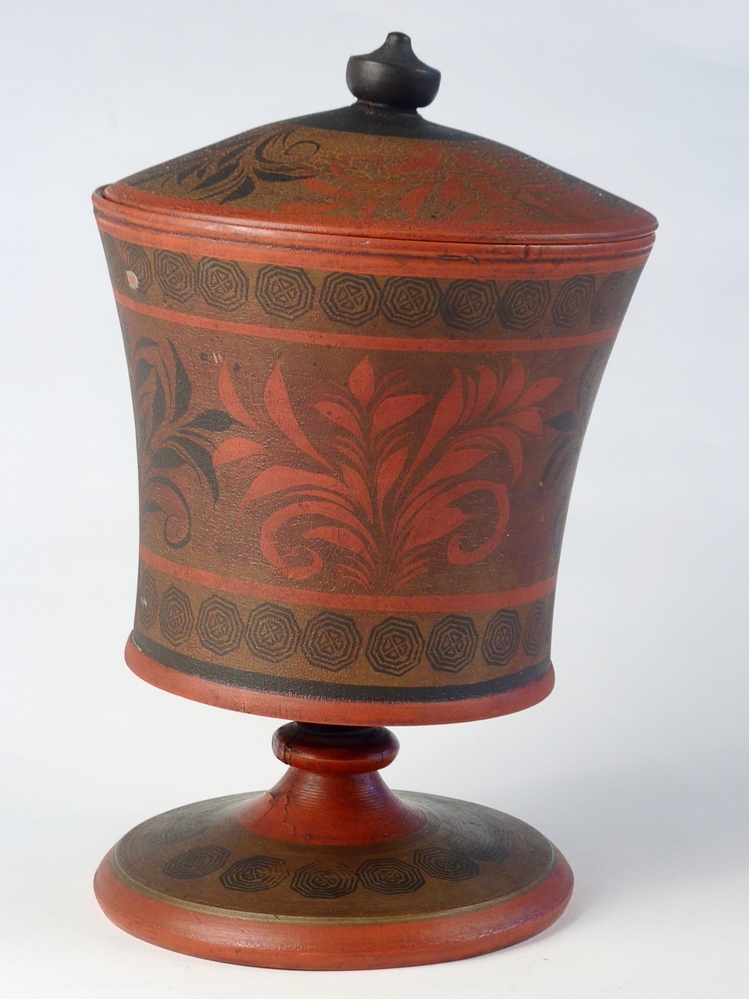 De Toejas is een cylindervormige doos gemaakt van berkenbast. De wand bestaat uit twee lagen berkenbast , die met de zilverwitte buitenkant van de schors tegen elkaar liggen. De deksel en bodem zijn gemaakt van een rond gesneden stukje grenehout. De doos is versierd met gestempelde en uitgesneden geometrische figuren.Deze dozen werden en worden nog steed vervaardigd in dorpen in de omgeving van Veliky Ustyug, een plaats in het Noordoosten van Europees Rusland. Zij worden in die streek "Tuyes" genoemd en door een groot deel van Noord - Oost Rusland verhandeld. In Rusland worden dit soort dozen nog steed gebruikt voor het vervoer van zuivelprodukten, terwijl ze in het Noorden van ons land als tabakspot dienst deden.