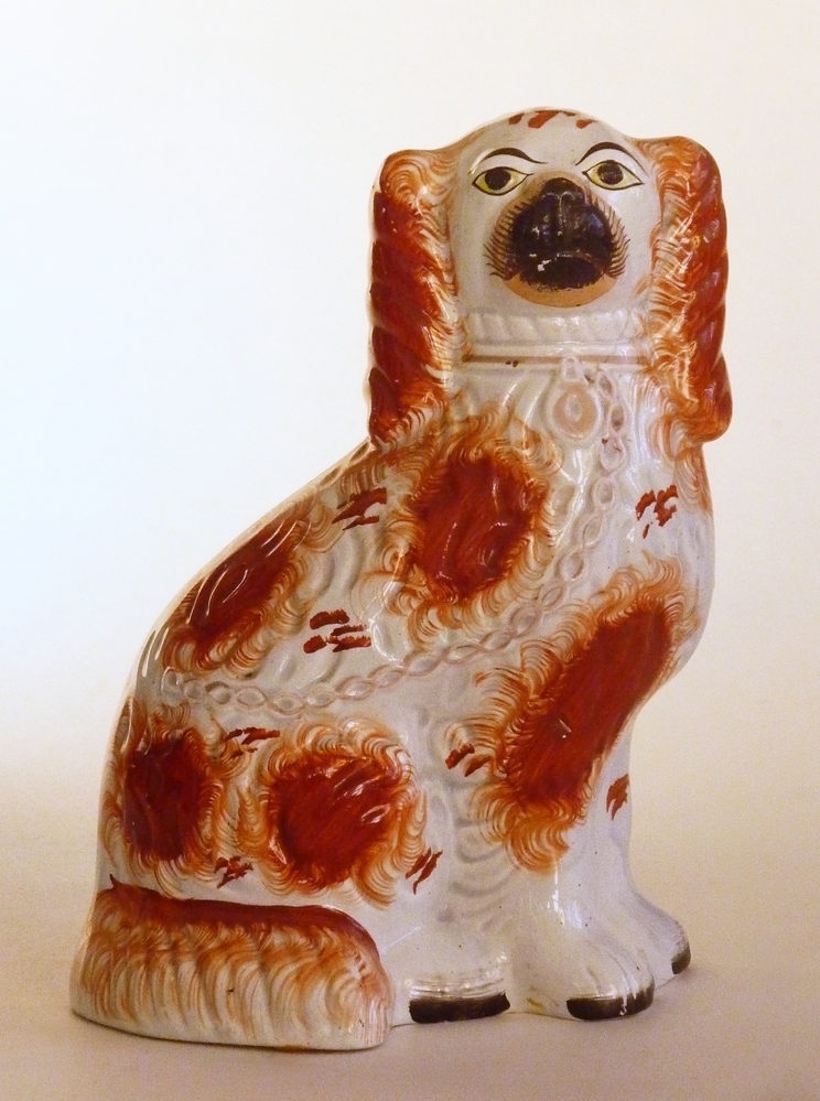 rechter model van een witte steengoed Spaniel met roodbruine decoratie op oren, als een zon uitwaaierende roodbruine vlekken op lichaam en staart, geel oogwit, zwarte snuit met roze ondergrond aan achterkant, zwarte nagels aan poten, poten vast aan lichaam, detail in lichaam, versleten bright gold lustre halsband en ketting, fikse beschadigingen aan achterkant, scheur in kop.