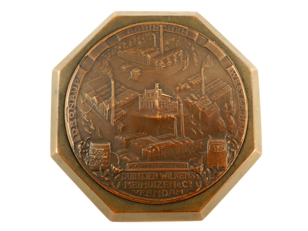 8 hoekige bronzen ere- of legpenning met op voorkant in cirkel in vogelvlucht de vijf fabrieken van Duintjer, Wilkens en Meihuizen, bovenaan Gorinchem, links Dronrijp, onder Oosterdiep, rechts Westerdiep en in het midden Veendam, aan onderkant in cartouche inscriptie Duintjer, Wilkens, Meihuizen & Co Veendam, geslagen door C.J. Begeer te Utrecht tussen 1910 - 1920