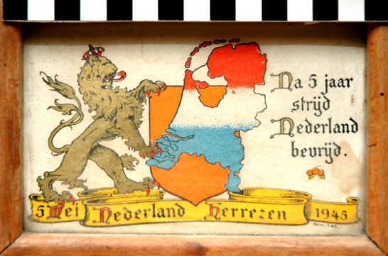 papieren plaat in houten lijst met afbeelding nederlandse leeuw en wapenschild met landkaart van Nederland in de kleuren rood wit en blauw met daaronder in gele banier de opschrift 5 mei Nederland Herrezen 1945 Na 5 jaar strijd Nederland bevrijd