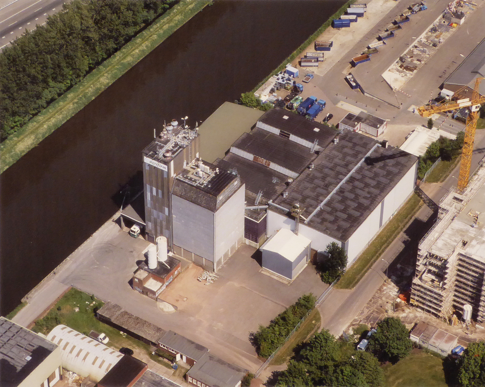 grote kleuren luchtfoto in aluminium lijst van  AGRIFIRM te Hoogezand, het voormalige COBO ( Cooperatieve Aan- en Verkoopvereniging Boerenbelang( opgericht in 1940 als Boerenbelang G.A. te Sappemeer, in 1965 door het samengaan van Coöperatie Noord-Oost te Veendam en Coöperatie Boerenbelang te Sappemeer gefuseeerd tot COBO, fuseerde met de aankoopcentrale in 1983 tot ACECO bv, fuseerde weer in 1990 tot ACM en in 2010 tot AGRIFIRM) te Hoogezand aan de van neckstraat.