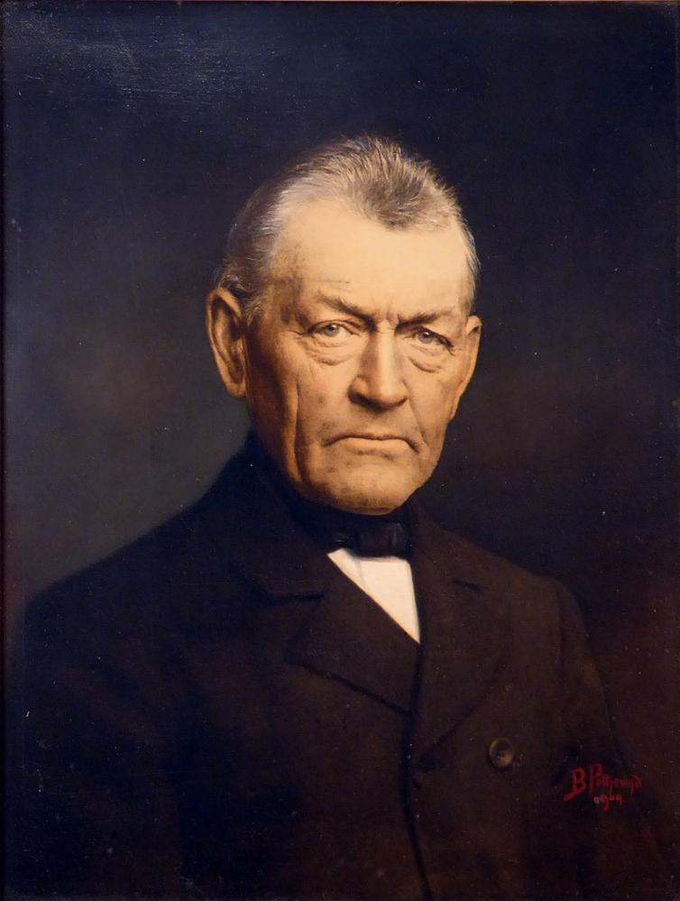 mansportret in goudkleurige rijkelijk decoreerde lijst op houten paneel, voorstellende een man in zwarte kledij, Harm Wieto Kuiper, geboren 17-10-1836 te Nieuwolda, overleden 7-12-1923 te Nieuwolda, getrouwd 14-02-1865 met Auke Klaasens Harhuis. Rechtsonder in rood gesigneerd B Pottjewijd 1909.