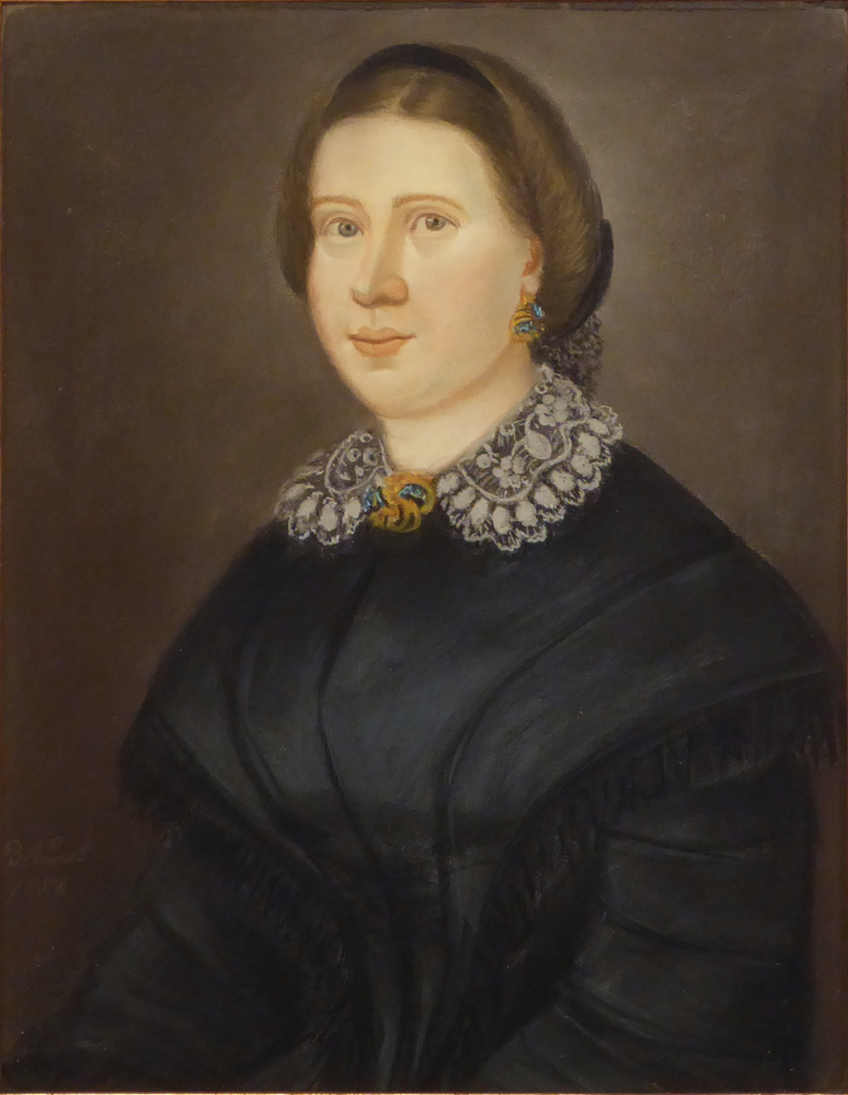 vrouwsportret in goudkleurige in de hoeken gedecoreerde gipsen lijst, voorstellende een vrouw met zwart jak en profil naar links, voorstellende Trijntje Dallinga, geboren 5-3-1836 te Schildwolde, overleden 18-3-1873 te Sappemeer, op 10-6-1858 te Slochteren gehuwd met Huge Smit, in 1858 te Tholen vervaardigd door kunstenaar Berend Wierts Kunst.