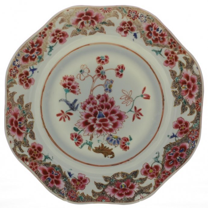 Achthoekige gelobde Chinese sierschotel uit de Qianglong periode (1736 - 1795), op voetring met platte onderglazuur bruingerande rand. Gedecoreerd in verschillende florale polychrome famille rose emaille (= een nieuwe roze emaille wat rond 1725 werd ontwikkeld, internationale naam hiervoor is de Chinese term Fancai) en goud. In het midden een bloeiende pioen, Chinese anjer en een lelie (dit zijn  symbolen voor een lang leven en eeuwige jeugd). Aan de zijkanten en rand pioenrozen, chrysanten en narcissen met bladeren, op spiraalvormige luiergrond. Op de keerzijde vier gestileerde lingzhi-paddestoelen symboliserend de onsterfelijkheid. Diameter circa 31 cm, datering c.1740 - 50 (in zilveren bordenhanger, op armen die uitlopen in een leeuwenkop die ring vasthoudt in hun bek een gehalteteken lopende leeuw 2 = gehalteteken voor zilver 1814 – 1953, en gestileerde jaarletter E = 1889, gemerkt op ring een zwaardje = gehalteteken kleine voorwerpen 1814 – 1905, en totaal versleten minervakop of meesterteken, aan binnenkant arm gegraveerd 33). De schotel is volgens veilingdocumentatie afkomstig uit het interieur van W.A. Scholten te Groningen. De schotel is op 9 december 1996 gekocht op een veiling bij het Venduhuis Van den Hende in Groningen, catalogus 176, lot 2523.