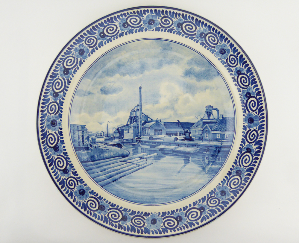 ronde aardewerken sierbord met aan binnenkant decoratie houthandel Meihuizen te Wildervank gelegen aan kanaal, met drijvende boomstammen, aan achterkant touw voor ophanging en opdruk: voor uw 65e verjaardag Ellen en Everhard, Marie en Jaap Dina en Jan Anneke en Hans. fabrieksmerk plateelbakkerij Zenith en initialen ceramist AS = Aart Stolk. Dirk Everhard Everts,( geb W.vank 07-07-1877, houthandelaar, overl. 25 juli 1952 Groningen) getrouwd met Anna Geertruida Dojes (Meeden 11-10-1883-† W.vank 17-05-1936) Dirk hertrouwde op 06-11-1939  met Susanna (Suze) de Beer,(geb. W. vank 25-02-1889) de weduwe van Jurjen Duintjer (W.vank 04-10-1885- † ald. 03-10-1937.  Het bord is dus van juli 1942. kinderen: Everhard Everts (31-12-1908 W.vank) laatste directeur Houthandel Meihuizen  en Ellen Mallin Kohmann (Oslo 18-11-1919) Marie Everts  (W.vank 16-05-1911) en Jacobus (Jaap) ten Sijthoff (landbouwer te Kommerzijl, geb. Amsterdam 13-06-01906) Arendina Catharina (Dina) Everts ( W.vank 09-04-1914) en Jan Jurriaan Schokking (bankdirecteur in Amsterdam geb. ald. 26-07-1903) Anna Alida (Anneke) Everts geb. W. vank 29-07-1919) en Pieter Hendrik (Hans) Suringar (advocaat te Rotterdam, geb. Malang, 13-09-1916)