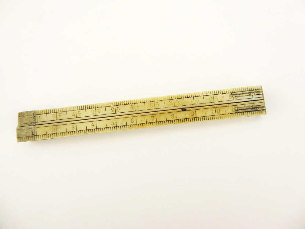 langwerpige benen meetlat bestaande uit 4 scharnierende delen, op de uiteinden versterkt met non - ferro metaal, met op voorkant schaalverdeling 1 cm - 50 cm, op achterkant Londense schaalverdeling 1 inch - 19 inch (1 inch = 2,54cm). Afkomstig uit de familie Everts, directeuren houthandel Meihuizen , Wildervank