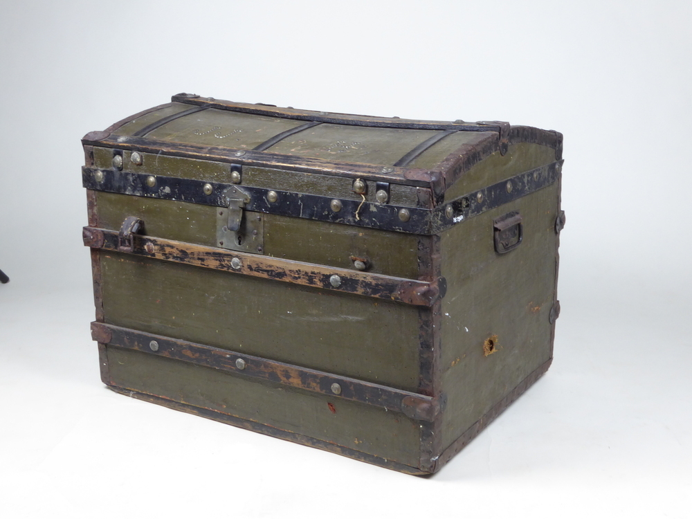 Hutkoffer met houten banden en bolle deksel, aan de randen en hoeken ijzeren beslag, op deksel in knopspijker J.J.H., binnenkant gevoerd met blauw wit gestreept papier en roze lint, binnenzijde deksel gemerkt K. Eisinga Veendam, zadelmaker en kofferfabriek, in de bocht der Kerkstraat, typ. Gebr. Mulder, Veendam, 53 cm hoog, 74 cm breed, 58 cm diep,
Klaas Johannes Eisinga, zadelmaker, geboren 20 mei 1848 te Groningen, overleden 21 januari 1917 te Veendam, zoon van Johannes Eisinga en Elizabeth Engelina Brus, getrouwd 1) op 23 december 1871 te Wildervank met Cornelia Lieben, geboren 11 januari 1849 te Wildervank, overleden 6 oktober 1889 te Veendam als dochter van Johannes Jozef Lieben en Alberdina Harms Panjer, getrouwd 2) op 7 januari 1891 te Veendam met Geertje Boll, geboren 4 maart 1841 te Rotterdam, overleden 7 augustus 1908 te Veendam, als dochter van Harm Egberts Boll en Hendrika Nannes van der Wijk, getrouwd 3) op 1 november 1913 te Veendam met Grietje Veentjer, geboren 19 juli 1850 te Wildervank, overleden 14 maart 1929 te Veendam, als dochter van Roelf Harms Veentjer en Geesje Jurriens Korrenga. De uit Groningen komende Eisinga’s waren zadelmakers van beroep, waarvan de eerste zich al rond 1840 in Veendam vestigde. Naast zadelmaker oefenden ze ook het vak uit van stoffeerder en behanger. Klaas Johannes gaf zich in 1884 op als lid van “Veenlust”. In 1885 lerverde hij aan “Veenlust”: Gedijnen voor 15 raam voor weg schoon en weer Gemaakt 6.25”. De rekening stond op een klein en verder blanco papiertje, geschreven in een onbeholpen, kinderlijk schrift. Op een dergelijk stukje papier, ook in 1885: Nota voor De Heeren van de “Cocitijt Veenlust van K.J.Eizinga 1 kleed schoongemaakt en gebragt 1.75 1 matras gemaakt 1.30 (totaal) 3.05. In 1898 was er toch een gedrukte rekening. De leverantie stelde zo goed als niets voor, maar… wie het kleine niet eert is het grote niet weert, en dat gold zeker in die tijd. Klaas Johannes Sr. kwam van B 175, het tweede huisje in de Kerklaan aan de zuidzijde, daarna tussen 1880 – 1890 aan de Kerklaan H 191 a, tussen 1890 – 1900 aan de Kerkstraat No 174 B, en ging tussen 1900 – 1920 naar de Kerkstraat H 792, gelegen aan het Kerkplein naast het huis van Dr. Tjabbes. In 1913 verhuisd het bedrijf naar het Beneden Oosterdiep. Meerdere zonen van Klaas Eisinga kozen dit beroep, en vestigden zich elders als stoffeerder door heel Nederland. Zoon Klaas Johannes emigreerde naar Amerika, waarschijnlijk omdat er teveel stoffeerders en zadelmakers kwamen.