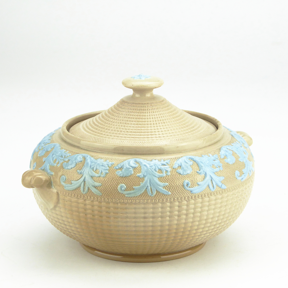 aardewerken suikerpot, engels, bruin met in relief blauwe geverfde bladdecor, op standring, onderkant geribbeld, aan zijkanten twee kleine uitsteeksels, oren / handgrepen, met deksel met knop, bovenop knop blauwe bloemdecoratie.