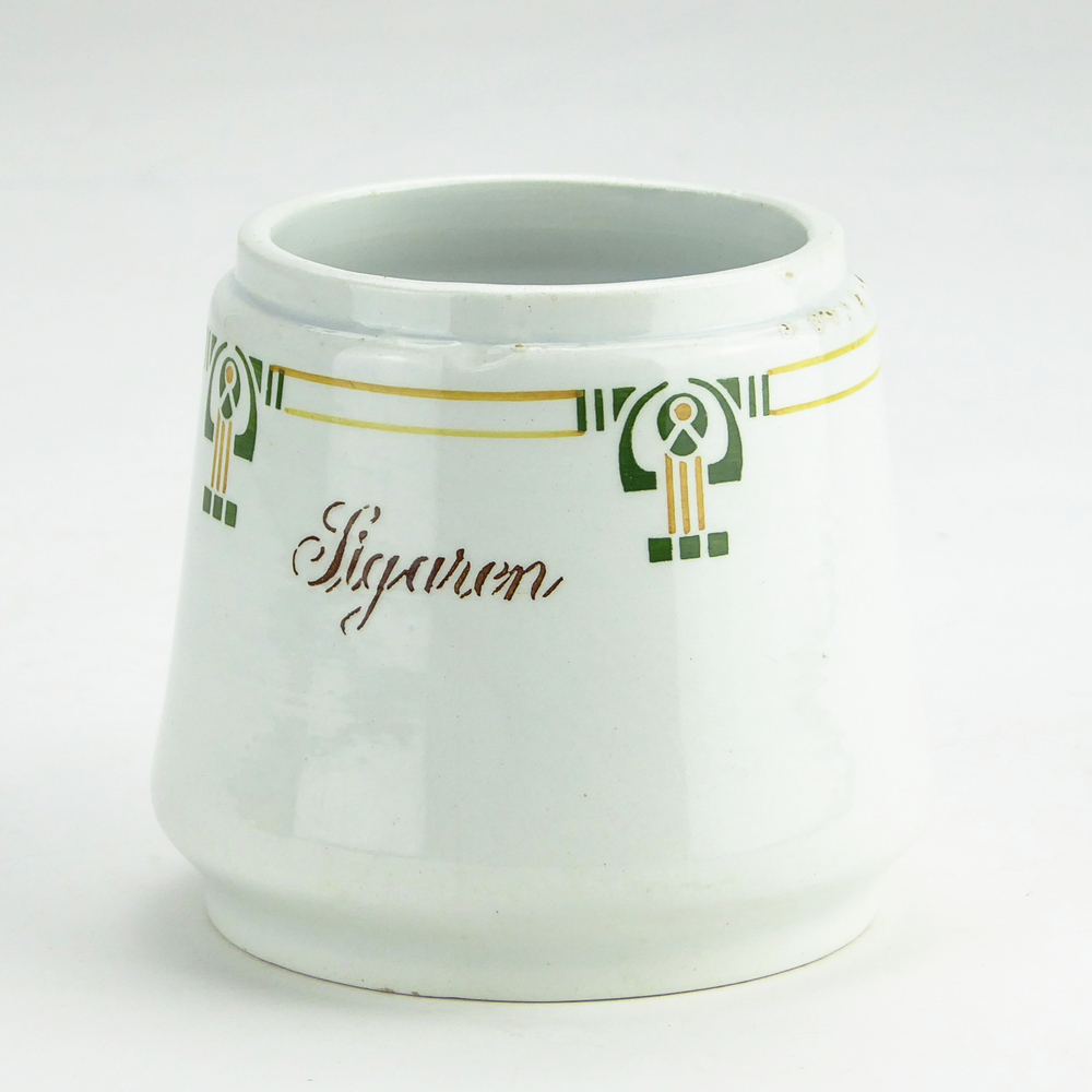 kleine iets taps toelopende aardewerken pot met bruine opdruk sigaren, rondom decoraties in bruin en groen gelijkende op een schep of een engelachtig figuur met de handen omhoog