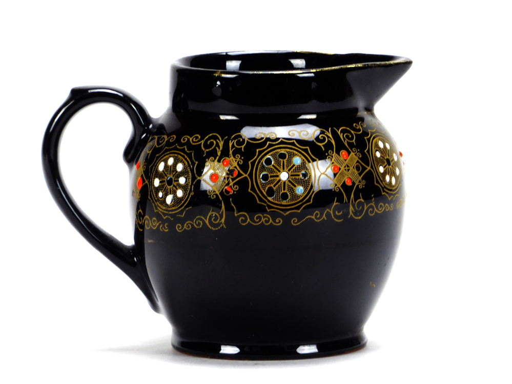 donkerbruin tegen zwart aan aardewerken roomkan, waarschijnlijk gemaakt in Japan, geometrische goudkleurige motieven , handbeschilderd met emaillen florale motieven, niet gemerkt aan onderkant, schenklip en ronde oor, afkomstig van zeevarende veenkoloniale familie