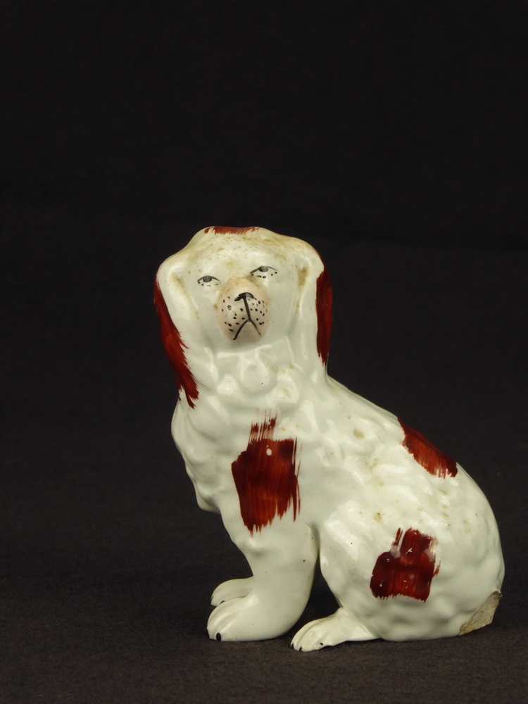 schoorsteenhond, wit met bruine oren, roze snuit, bruine met penseel gezette decoratie op kop, rug en poten, poten los van het lichaam, dikke opgezette nek, gat aan onderkant, waarschijnlijk een Water Spaniel.